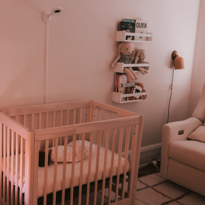 baby sleeping in crib while nanit pro camera + wall mount is on wall in room #mount_wall mount